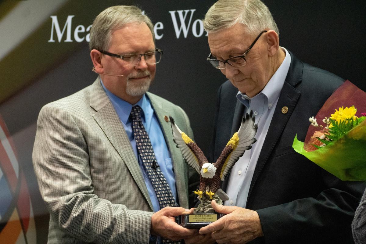 TIm Burrow giving the Gray Eagle to Bill Yasko