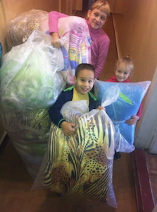 Children helping with bedding for refugees