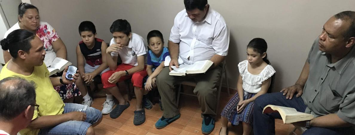 Daniel (in the yellow shirt) sharing lessons from his solar player with a small group of Christians