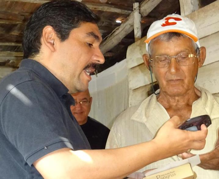 Arthur Puente showing a Cuban preacher how to use the solar player